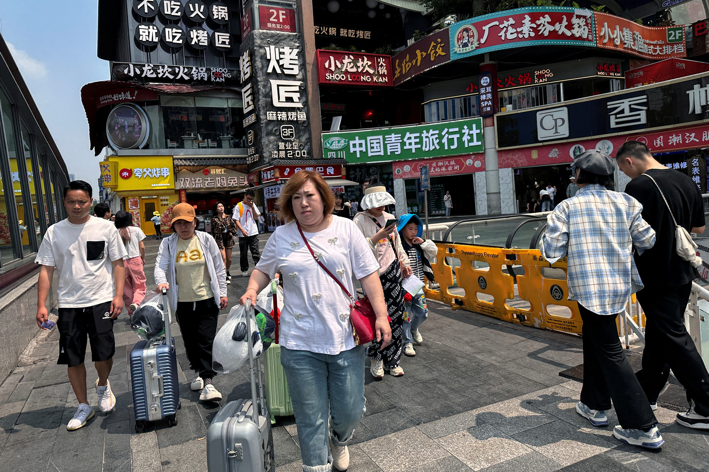 Người dân đi qua một nhà hàng ở Thành Đô (Tứ Xuyên, Trung Quốc) tháng 4/2024. Ảnh: Reuters