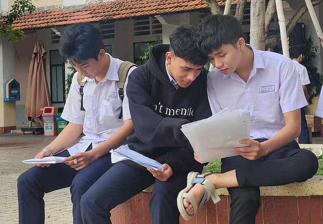 Thí sinh tranh thủ xem lại bài ở điểm thi THCS Trần Văn Ơn, TP HCM, lúc 6h20, ngày 27/6. Ảnh: Nhật Lệ