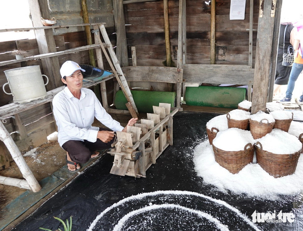 Anh Nguyễn Ngọc Thơ giới thiệu sa quạt chuyển nước từ ô ruộng muối này qua ô kia. Anh Thơ cho biết: xưa kia tát 420 m2 nước làm trong 45 phút, nay chỉ việc cắm điện ngồi hút điếu thuốc là xong - Ảnh: T.T.D. Anh Nguyễn Ngọc Thơ giới thiệu sa quạt bằng tay chuyển nước từ ô ruộng muối này qua ô kia. Anh Thơ cho biết: Xưa kia tát 420m³ nước làm trong 45 phút, nay chỉ việc cắm điện ngồi hút điếu thuốc là xong - Ảnh: T.T.D.