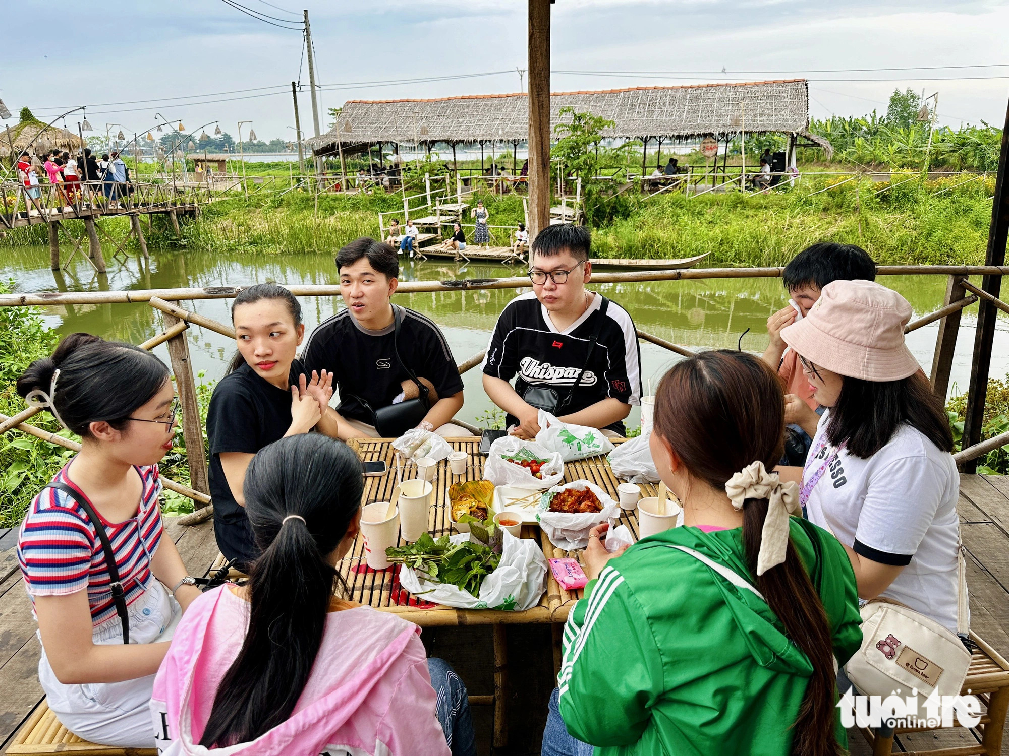 Chợ quê xanh từ vật liệu trang trí đến đồ đựng thức ăn- Ảnh 3. Nhóm du khách thưởng thức món ăn tại chợ
