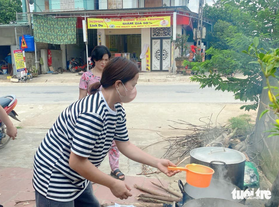 Thầy cô nấu chè, ép nước mía tiếp sức học sinh ôn thi tốt nghiệp THPT- Ảnh 2. Các cô giáo hì hụi chuẩn bị củi, nhóm bếp để nấu chè đậu đỏ - Ảnh: TÂM PHẠM