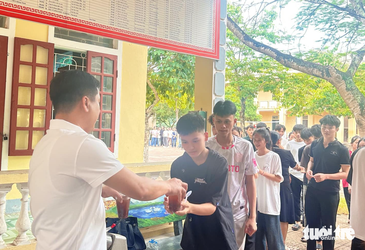 Thầy cô nấu chè, ép nước mía tiếp sức học sinh ôn thi tốt nghiệp THPT- Ảnh 5. Học sinh xếp hàng ngay ngắn nhận chè sau giờ giải lao ôn thi - Ảnh: TÂM PHẠM