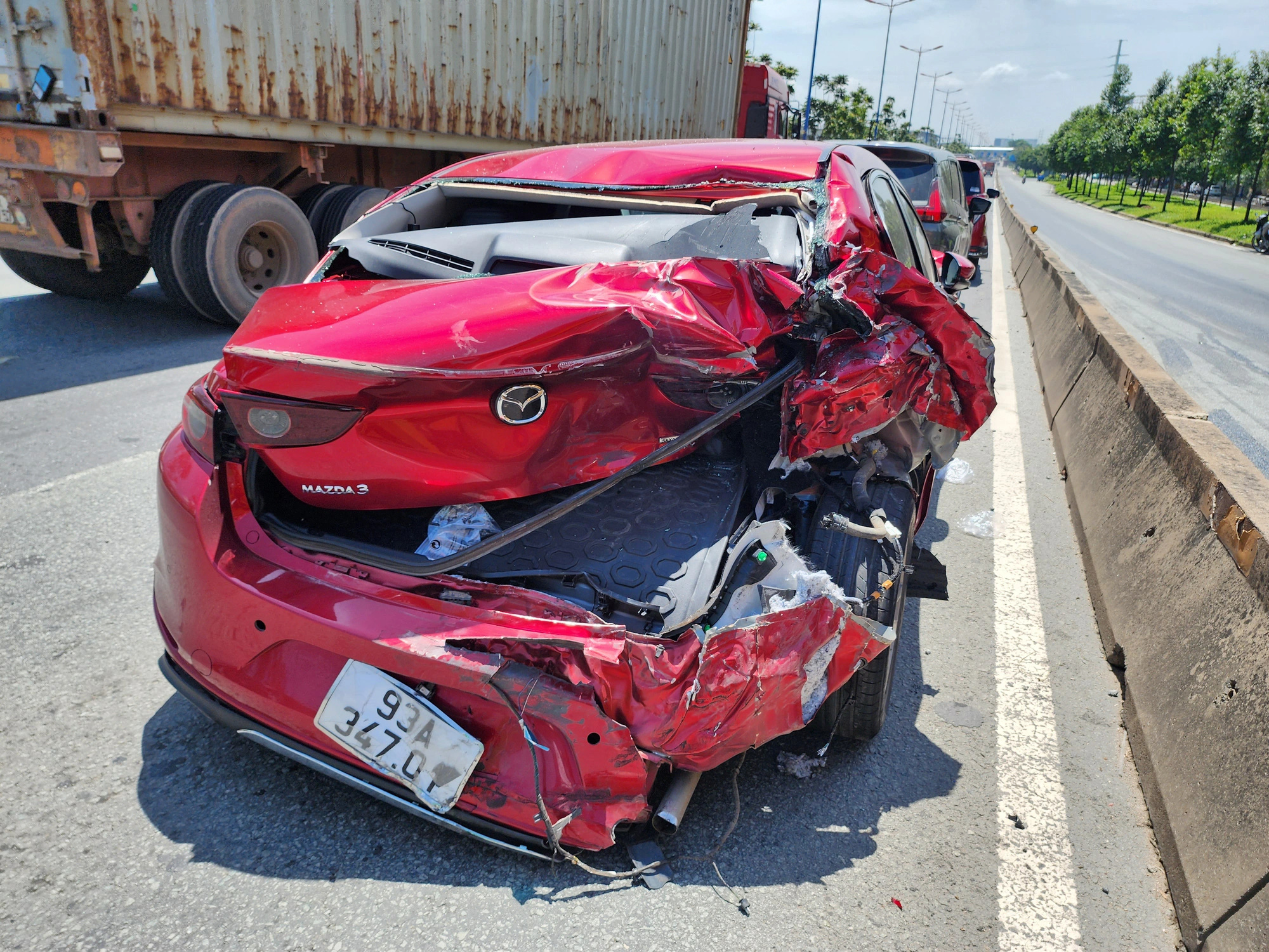 Tai nạn liên hoàn 4 xe trên xa lộ Hà Nội, kẹt xe 3km- Ảnh 2. Đuôi một ô tô trong vụ tai nạn nát bươm - Ảnh: MINH HÒA