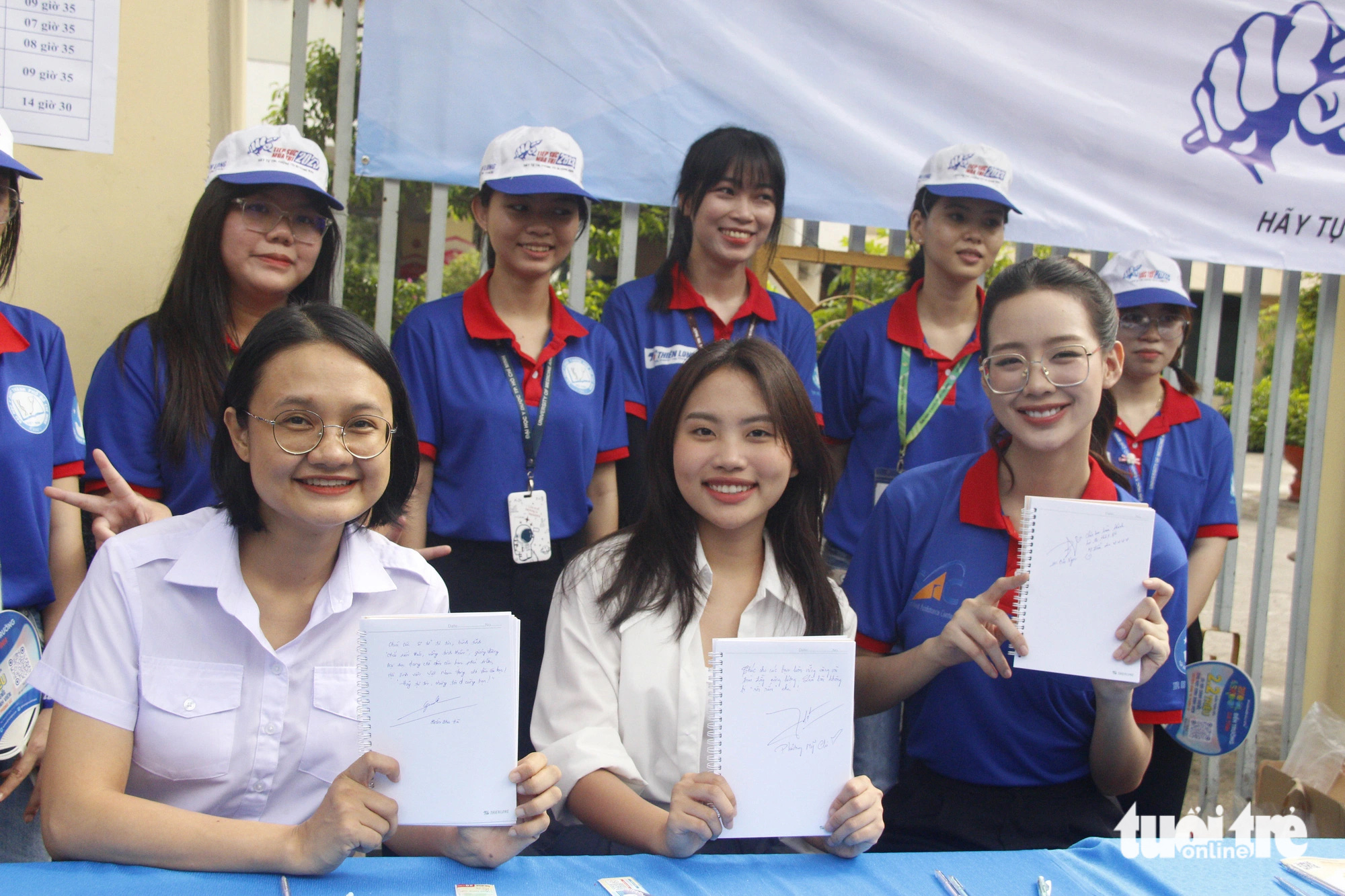 Sinh viên tình nguyện TP.HCM tặng quà, chăm sóc sức khỏe cho thí sinh- Ảnh 4. Chị Trần Thu Hà, phó bí thư Thành Đoàn TP.HCM, ca sĩ Phương Mỹ Chi và hoa hậu Lê Nguyễn Bảo Ngọc (hàng đầu, từ trái sang) viết lời chúc gửi đến các sĩ tử - Ảnh: CÔNG TRIỆU