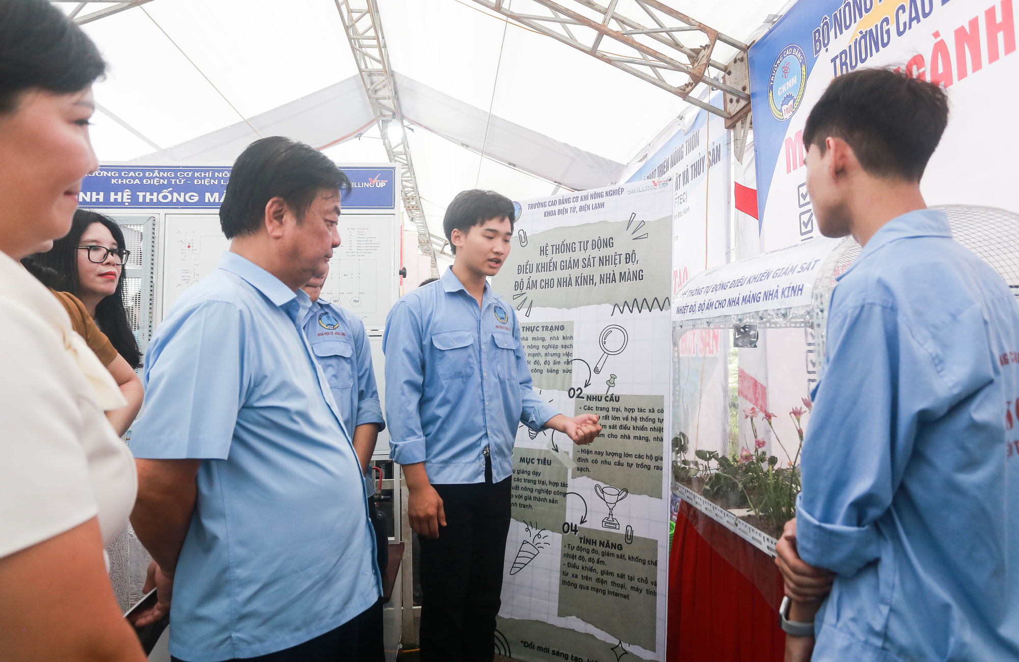 Khởi nghiệp thành công với cây tía tô 'nhờ' dịch COVID-19- Ảnh 1. Bộ trưởng Lê Minh Hoan (thứ 3 từ trái) nghe chia sẻ về mô hình giám sát nhiệt độ, độ ẩm cho nhà màng, nhà kính của sinh viên - Ảnh: C. TUỆ