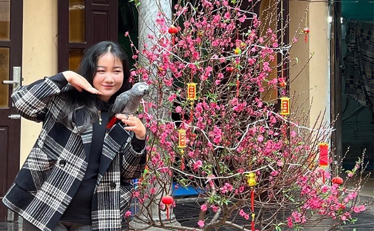 Hương Giang và chú vẹt xám Maika đón Tết 2024 tại quê nội ở Hưng Yên. Ảnh: Nhân vật cung cấp