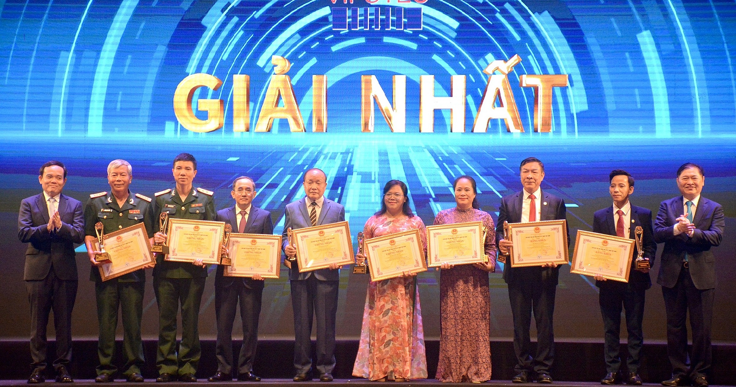 Phó thủ tướng Trần Lưu Quang (bìa trái) và TSKH Phan Xuân Dũng (bìa phải) trao bằng khen cho các tác giả công trình đoạt giải nhất. Ảnh: La Duy