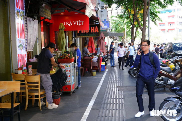 Nhiều quận, huyện ở TP.HCM chậm triển khai thu phí vỉa hè- Ảnh 1. Đường Hải Triều, quận 1 thông thoáng hơn sau thời gian thí điểm thu phí sử dụng tạm vỉa hè. Xe máy được xếp gọn gàng, người đi bộ trên vỉa hè thoải mái, an toàn hơn - Ảnh: THU DUNG