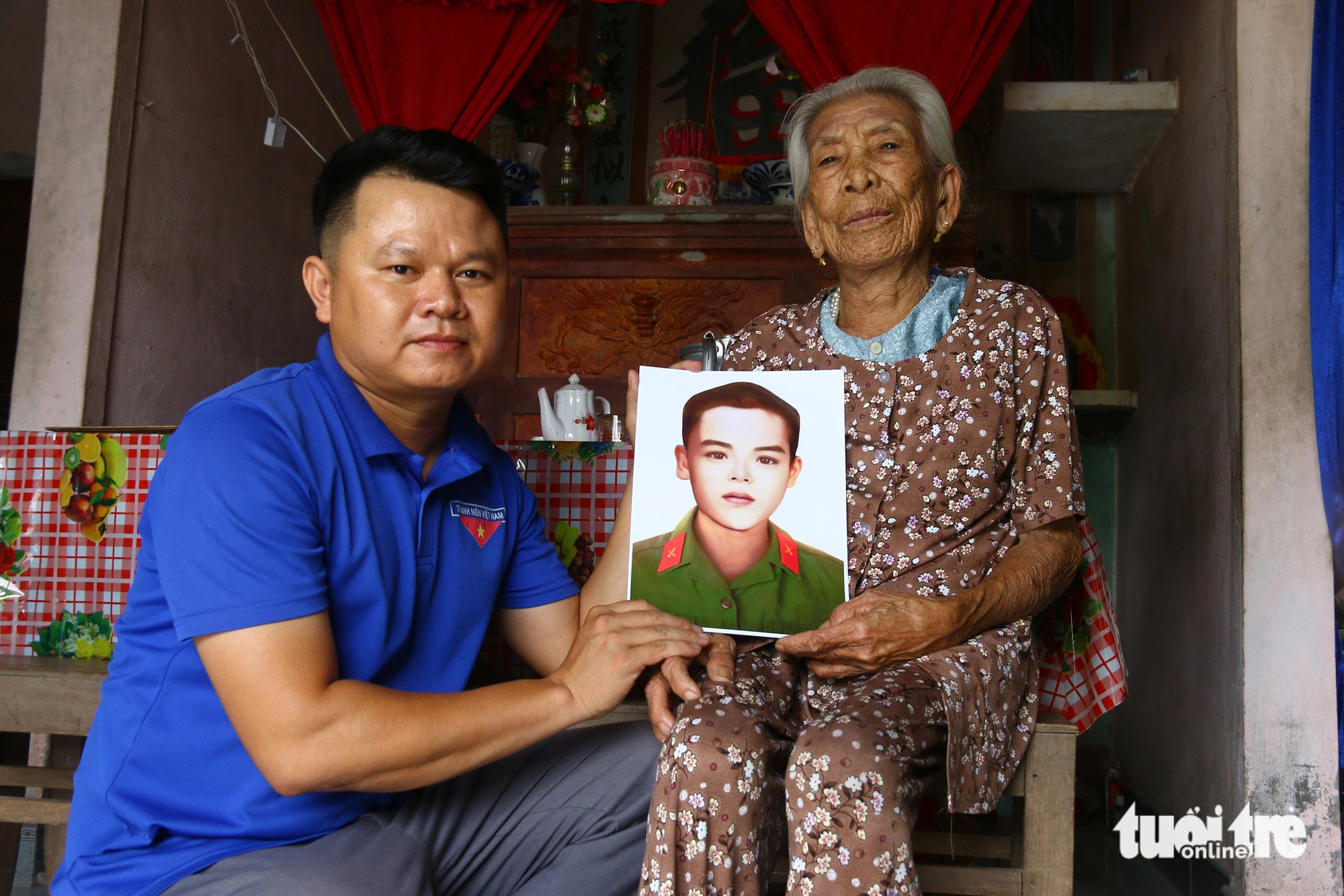 Chàng bí thư xã đoàn tìm lại dáng hình các Anh hùng liệt sĩ- Ảnh 1. Anh Hồ Xuân Hoàng (bí thư Đoàn xã Quảng Thái, huyện Quảng Điền, Thừa Thiên Huế) tặng lại di ảnh liệt sĩ Phan Thịnh đã được anh phục hồi lại cho mẹ Việt Nam anh hùng Văn Thị Giao - Ảnh: NHẬT LINH