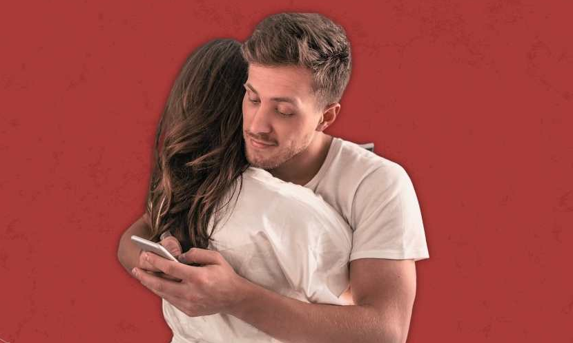 Một người sử dụng smartphone khi đang ôm bạn gái. Minh họa: Bonobology