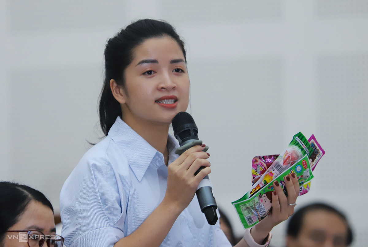 Đại biểu Trần Thị Khánh Linh cầm kẹo trôi nổi mua trước cổng trường chất vấn Giám đốc Sở Công thương tỉnh Nghệ An. Ảnh: Đức Hùng