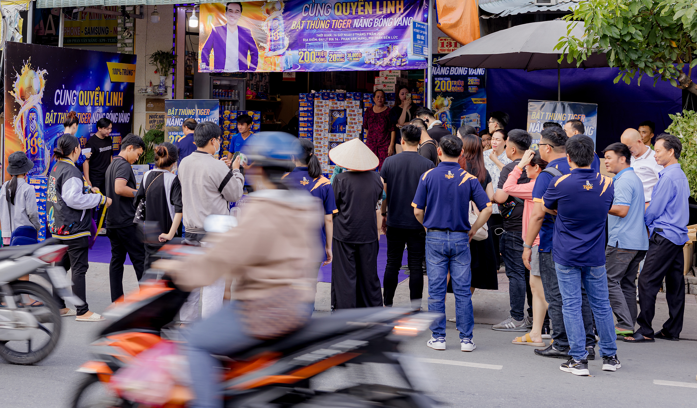 Người dân xếp hàng đến giao lưu cùng Quyền Linh tại một điểm bán hàng ở Bến Lức, Long An. Ảnh: XIN TÊN NGƯỜI CHỤP