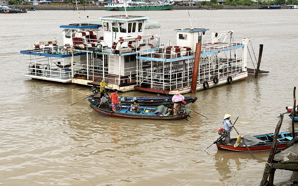 Ba chiếc phà ngưng chạy, trong khi nhiều xuồng nhỏ đưa rước khách qua lại sông Cần Thơ. Ảnh: An Bình