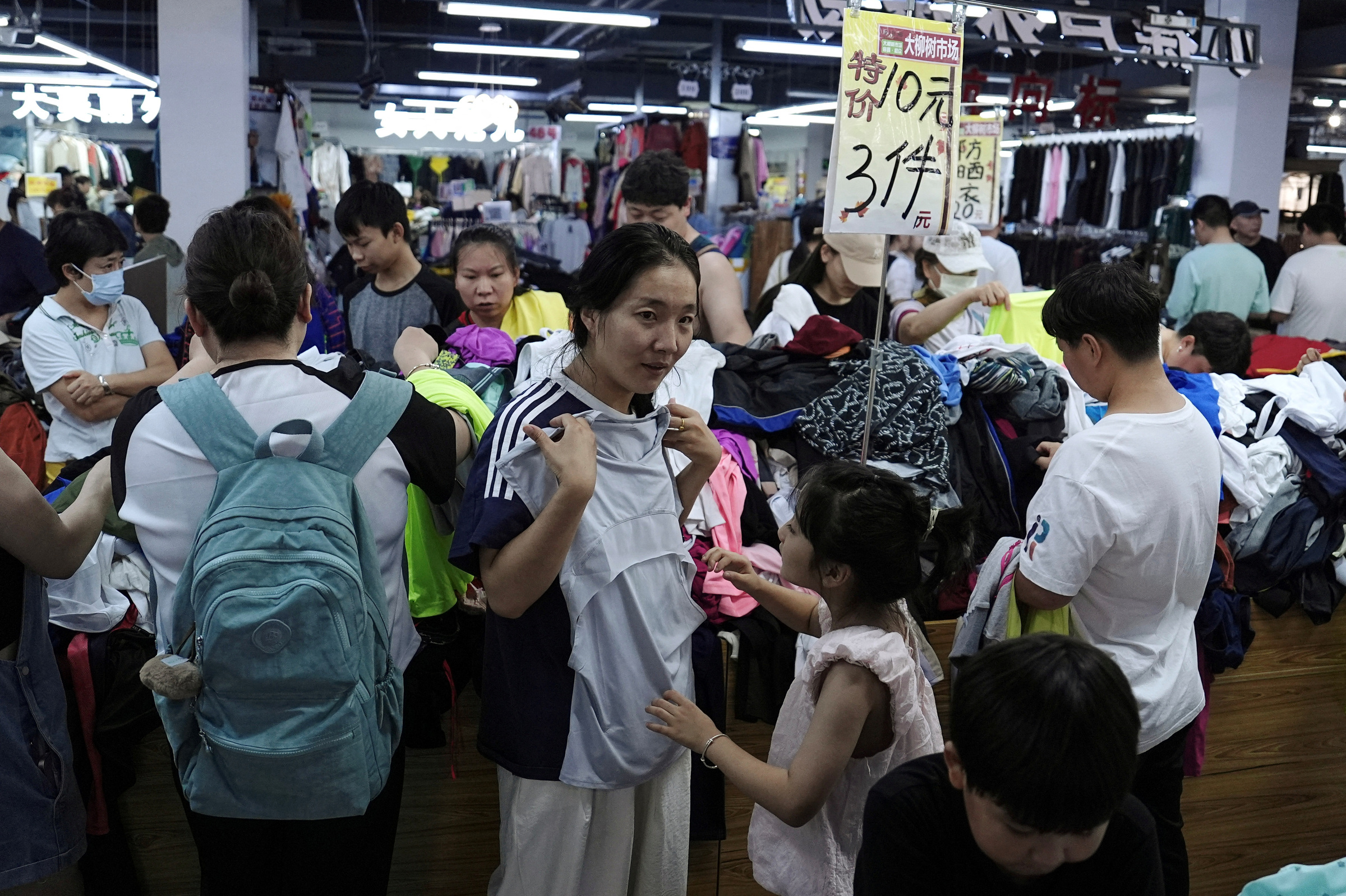 Khách hàng mua sắm tại một cửa hàng quần áo giảm giá ở Bắc Kinh ngày 14/7. Ảnh: Reuters