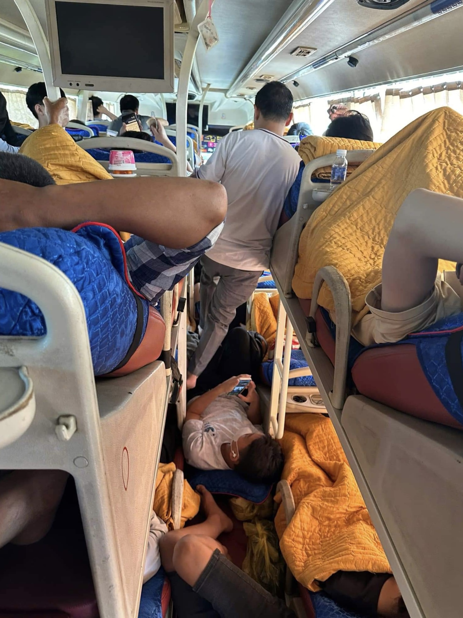 Tuấn Tú và nhiều hành khách phải nằm hoặc ngồi dọc lối đi của xe khách tuyến Hà Nội - Nghệ An do hết giường nằm, đầu giờ chiều 30/8. Ảnh: Nhân vật cung cấp