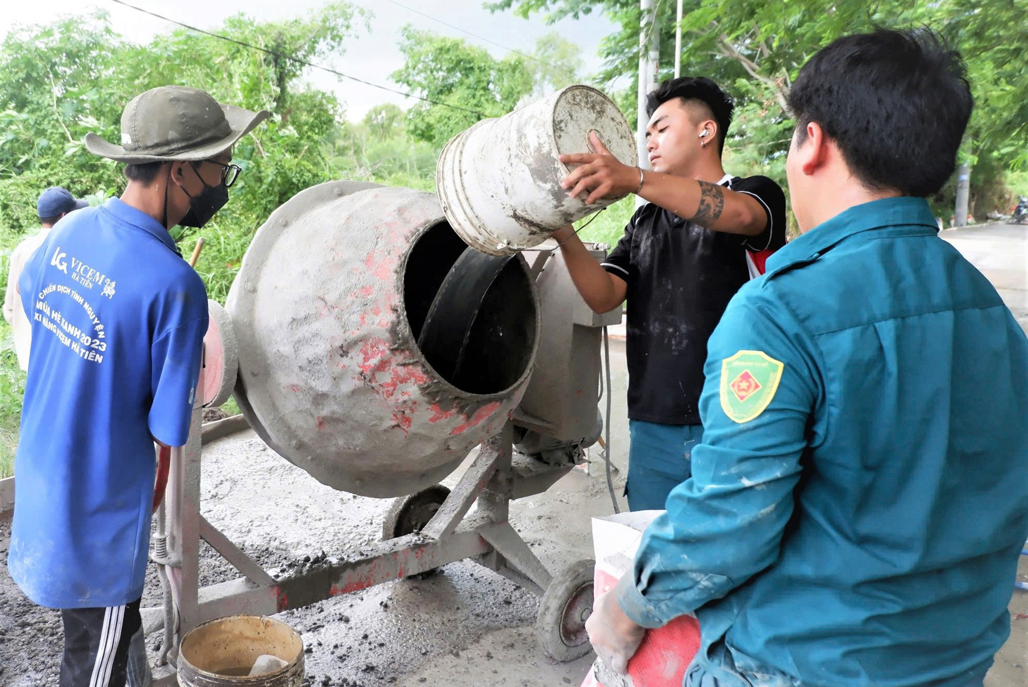 Các chiến sĩ tình nguyện hè 2024 cùng bê tông hóa đường Xương cá 1 tại ấp 3, xã Long Thới, huyện Nhà Bè (TP.HCM) - Ảnh: K.ANH Con đường ghi dấu chân tình nguyện- Ảnh 1.