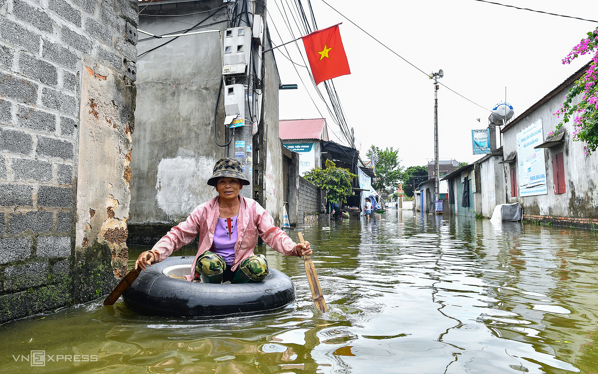 Bà Phùng Thị Khánh nhà làng Hạnh Bồ, xã Nam Phương Tiến, đi lại bằng thuyền tự chế trong những ngày cuối tháng 7, đầu tháng 8. Ảnh: Giang Huy