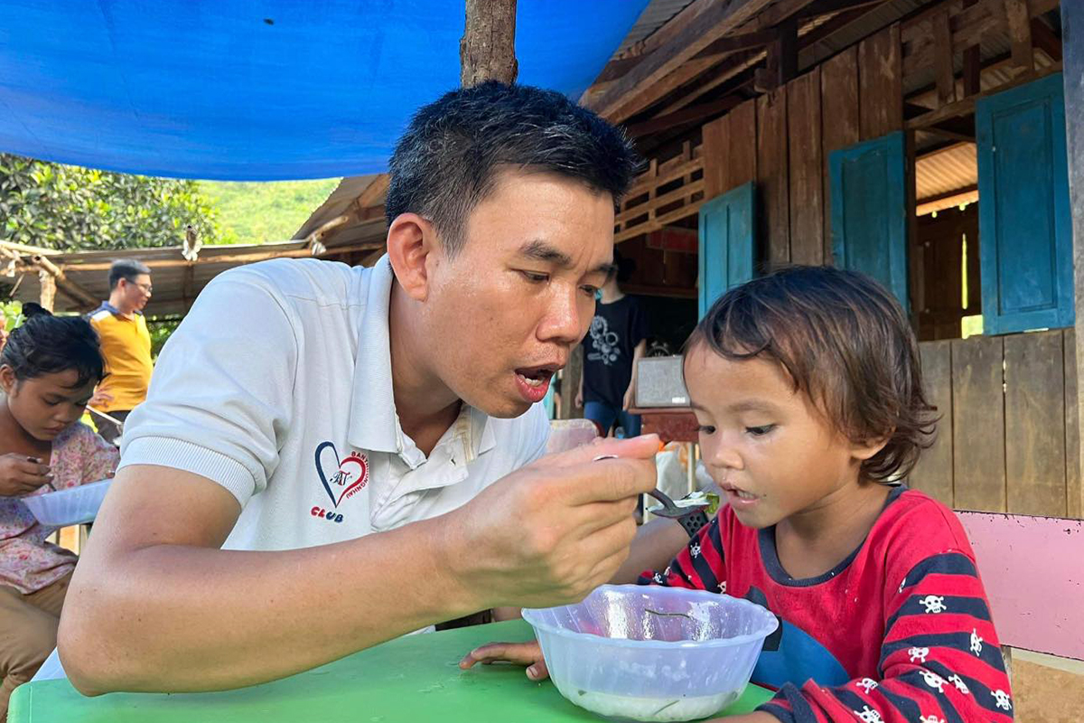 Anh Nguyễn Bình Nam chăm sóc bữa ăn cho một trẻ vùng cao. Ảnh: Nhân vật cung cấp