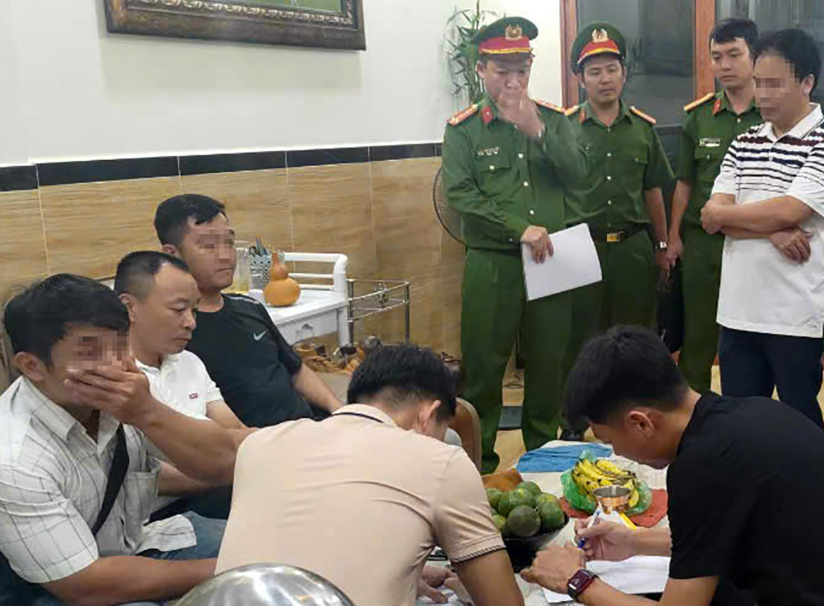Hoàng Văn Thảo (thứ 2, bên trái) khi bị cảnh sát đưa về nơi tạm trú, khám xét, thu giữ tang vật. Ảnh: Công an cung cấp