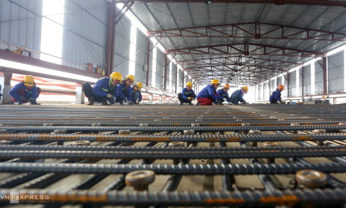 Công nhân đang bắn đinh, lắp lưới thép để đổ bê tông siêu tính năng. Ảnh: Bá Đô