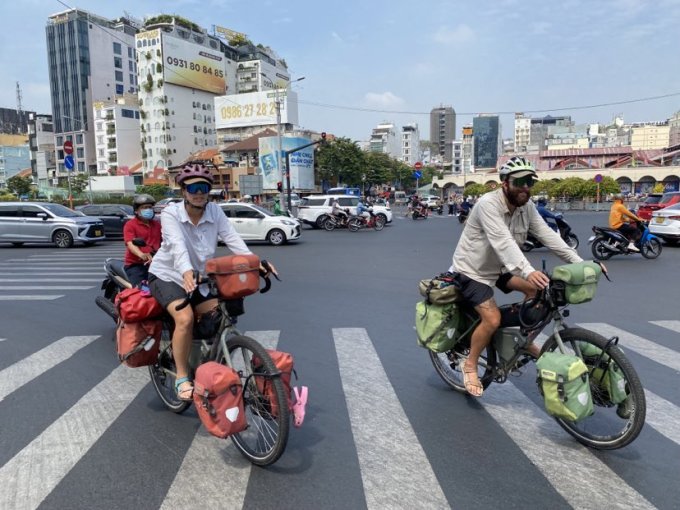 Alessia và Stefano đạp xe ở gần chợ Bến Thành, quận 1, TP HCM, sáng 12/1. Ảnh: Ngọc Ngân