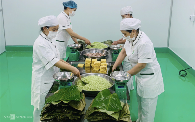 Bốn nhân viên đang gói bánh chưng. Ảnh: Đắc Thành
