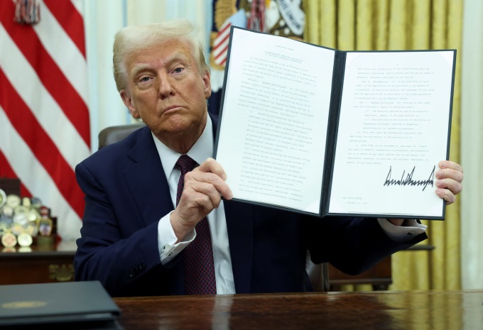 Tổng thống Mỹ Donald Trump nắm giữ một sắc lệnh hành pháp đã ký về tiền số tại Nhà Trắng, ngày 23/1. Ảnh: Reuters