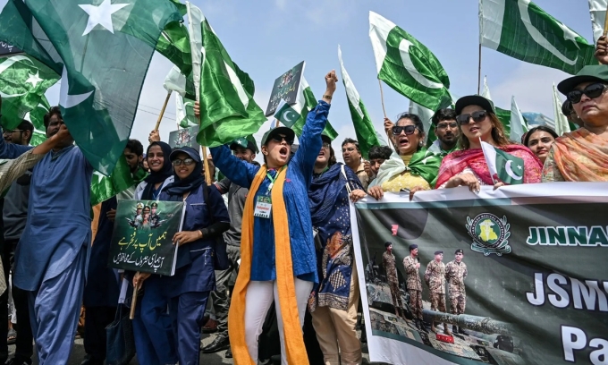 Học sinh và giáo viên cầm cờ Pakistan tham gia một cuộc biểu tình phản đối Ấn Độ và bày tỏ đoàn kết với lực lượng vũ trang tại Karachi hôm 15/5. Ảnh: AFP