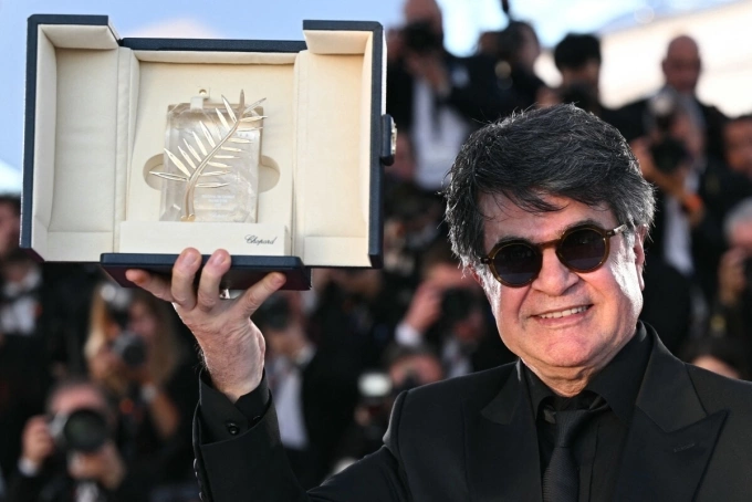 Đạo diễn Jafar Panahi chụp ảnh cùng chiếc cúp Cành Cọ Vàng ở bế mạc Liên hoan phim Cannes 2025. Ảnh: AFP
