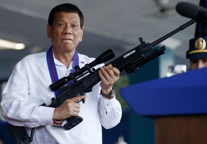 Ông Rodrigo Duterte cầm khẩu súng trường tại trụ sở của Cảnh sát Quốc gia Philippines ở thành phố Quezon tháng 4/2018. Ảnh: AP