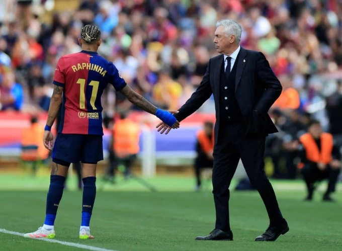 Ancelotti (phải) bắt tay Raphinha, người sẽ là học trò của ông ở tuyển Brazil, sau trận Barca 4-3 Real ở vòng 35 La Liga tối 11/5. Ảnh: Reuters