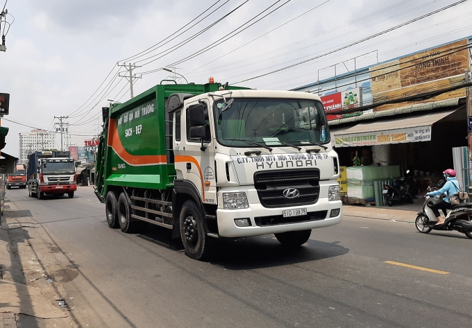 Xe chở rác chạy trên quốc lộ 50, huyện Bình Chánh. Ảnh: Giang Anh