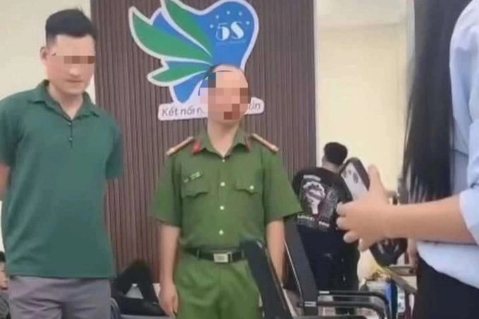 Người đàn ông áo xanh (bên trái) được cho là cán bộ Công an phường trong sự việc. Ảnh: Cắt từ video