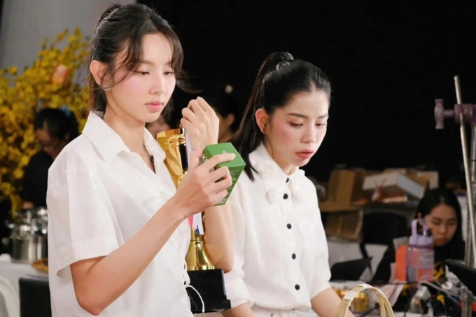 Hoa hậu Thùy Tiên (trái) trong một buổi bán hàng.