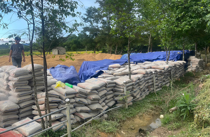 Hơn 200 tấn xi măng được tập kết tại sân vận động thôn Bình Phúc, xã Lộc Yên, phía trên phủ bạt bảo quản sơ sài. Ảnh: Đức Hùng