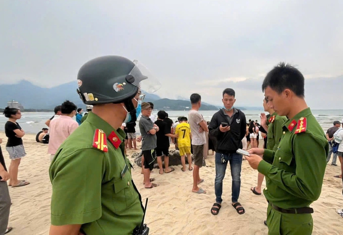 Lực lượng công an và người dân ghi nhận sự việc tại khu vực bãi biển xảy ra sự việc. Ảnh: Niệm Viết